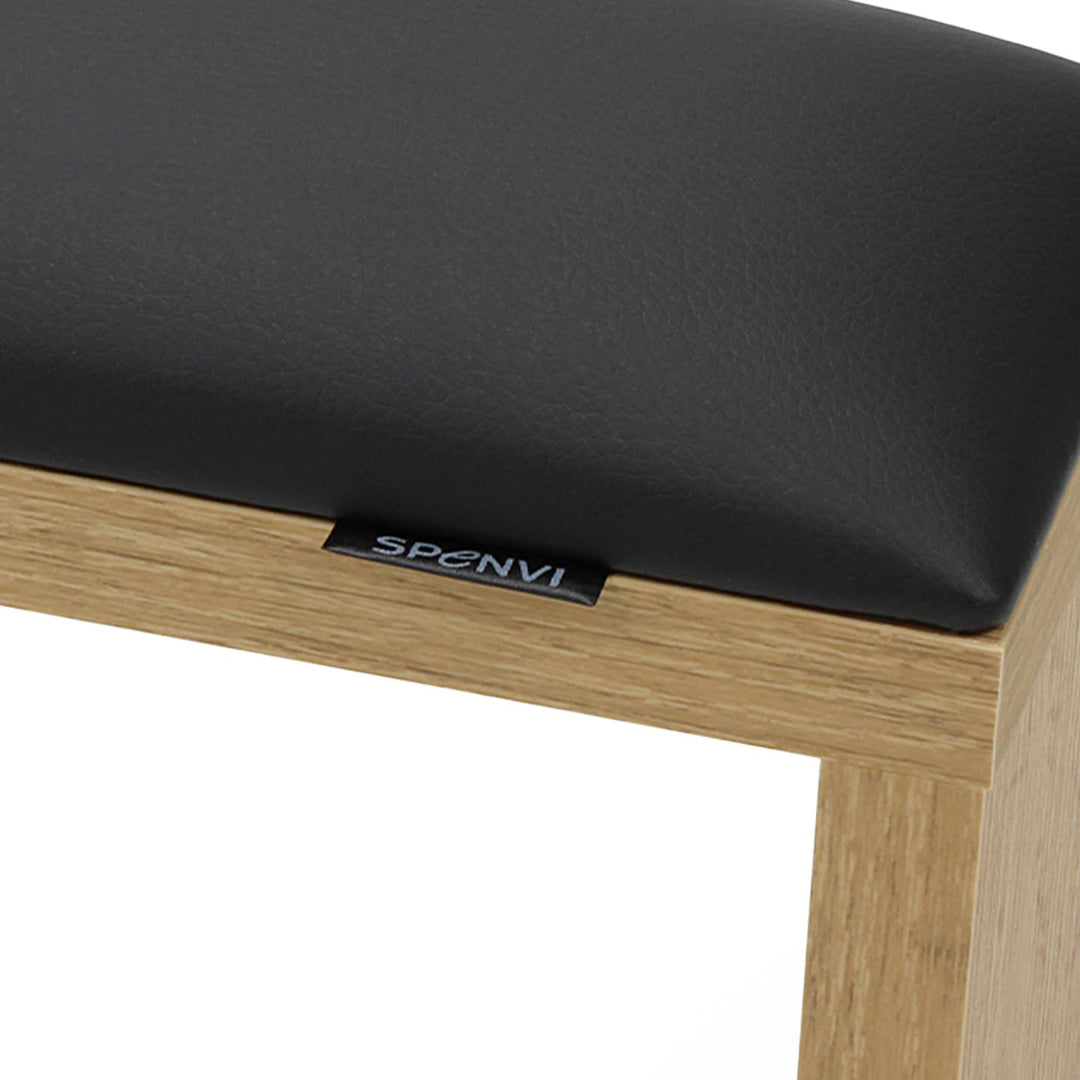 Close-up of SPENVI Classic arm rest showing black leather texture, oak-finish frame, and subtle SPENVI brand tag. #color_black