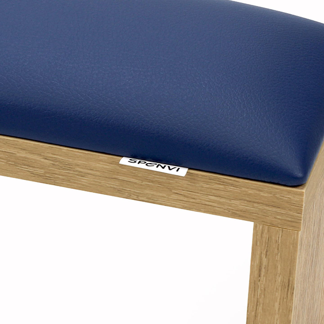 Close-up of SPENVI Classic manicure arm rest with navy blue leather cushion and oak-finish wooden base. #color_blue