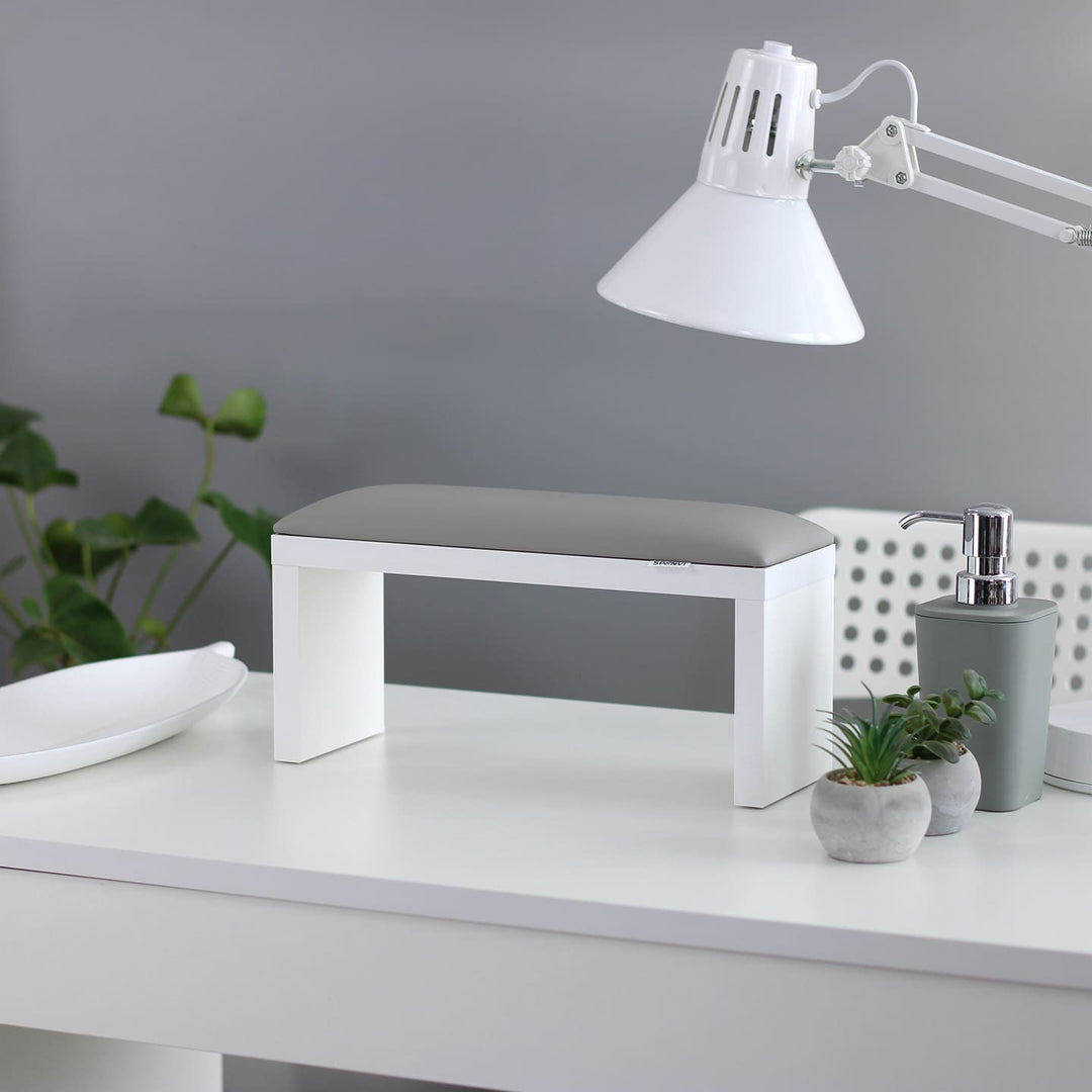 SPENVI Classic manicure arm rest with light gray leather cushion and white-finish legs on a modern salon desk. #color_cloud