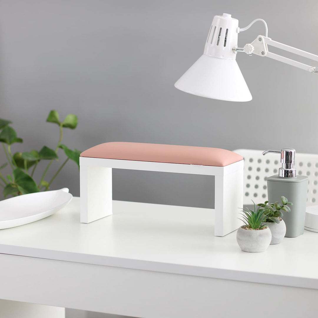 SPENVI Classic manicure arm rest with light pink leather cushion and white-finish legs on a modern salon desk. #color_light-pink