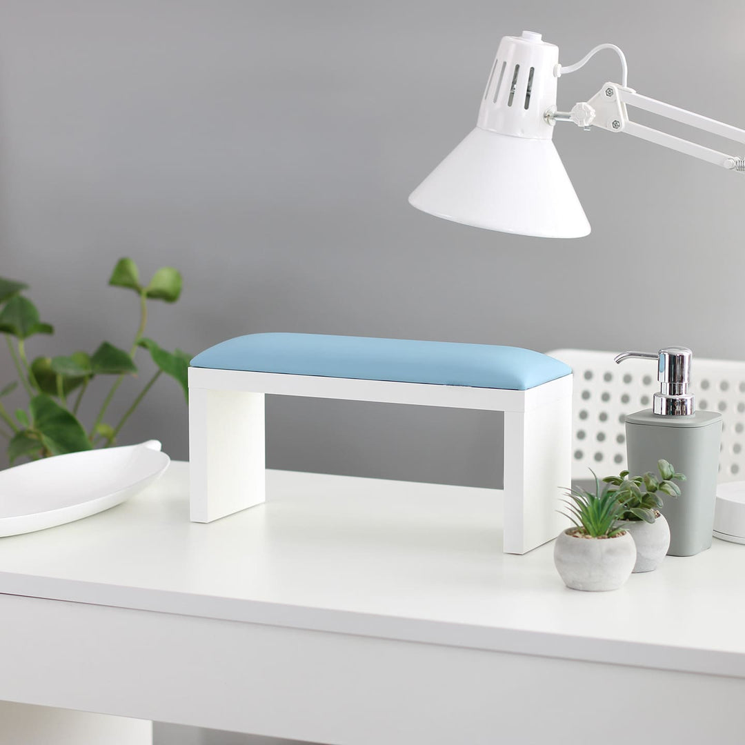 SPENVI Classic manicure arm rest with sky blue leather cushion and white-finish legs on a modern salon desk. #color_sky-blue