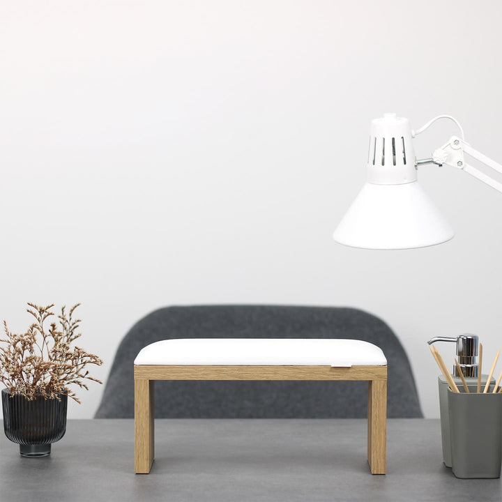 SPENVI Classic manicure arm rest with white leather cushion and oak-finish legs on modern salon desk under white lamp. #color_white