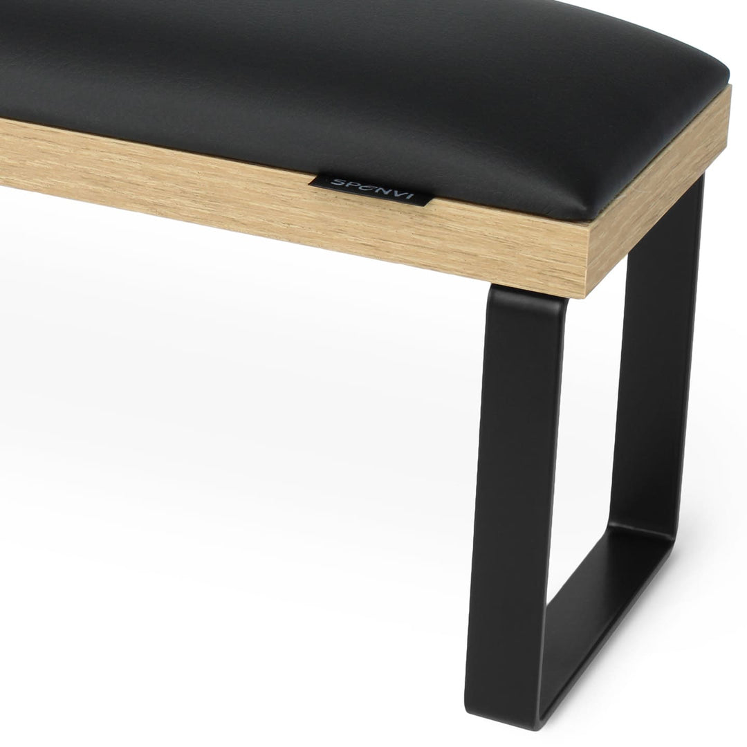 Side view of SPENVI Loft arm rest showing smooth black leather cushion, oak-finish base, and black metal legs. #color_black
