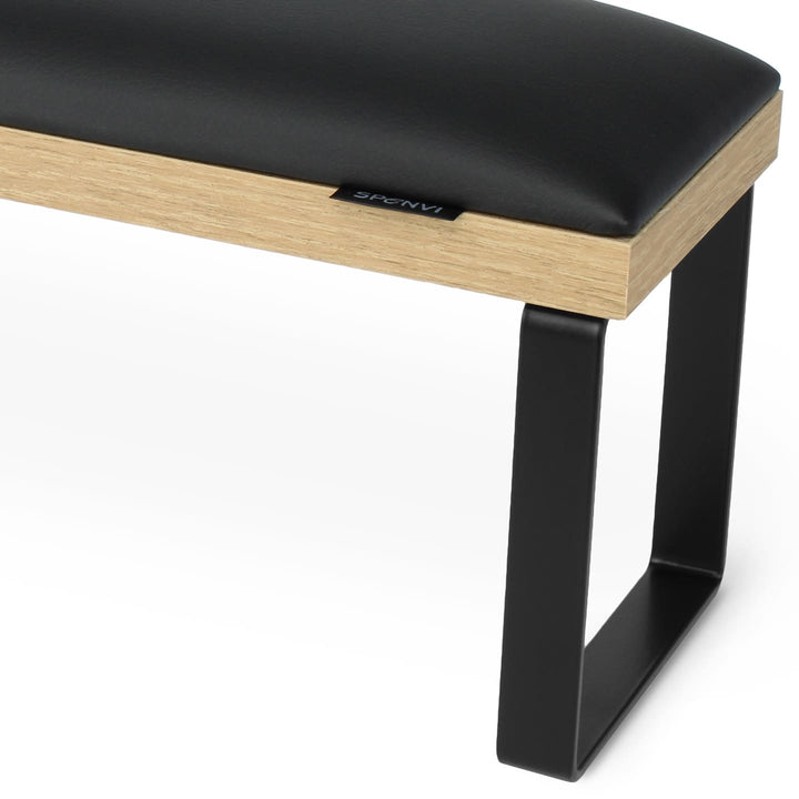 Side view of SPENVI Loft arm rest showing smooth black leather cushion, oak-finish base, and black metal legs. #color_black