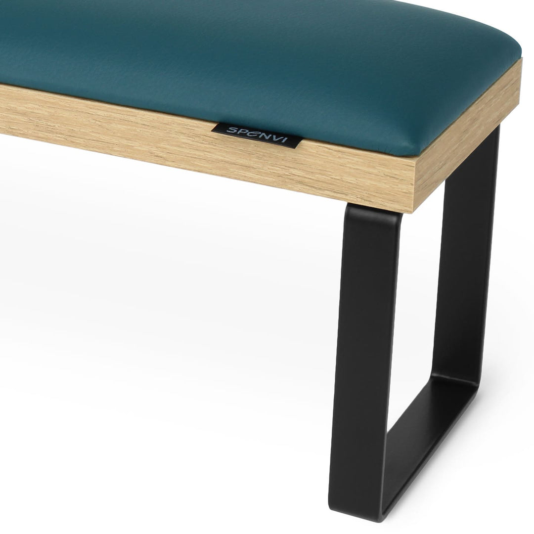 Side view of SPENVI Loft arm rest showing smooth dark green leather cushion, oak-finish base, and black metal legs. #color_dark-green
