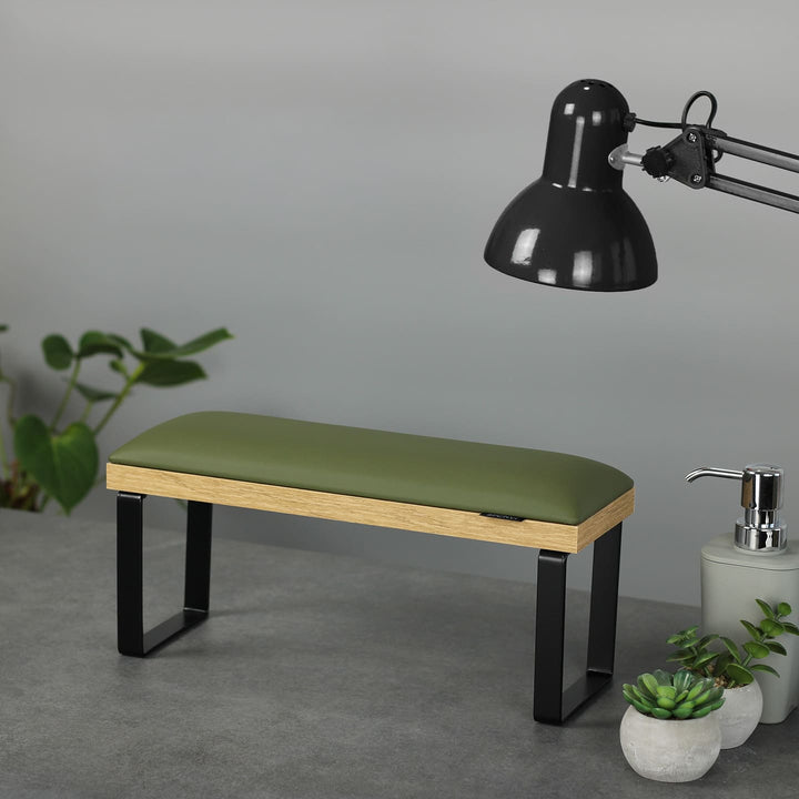 SPENVI Loft manicure arm rest with khaki leather cushion, oak-finish base, and black metal legs on modern salon desk with lamp and plants. #color_khaki