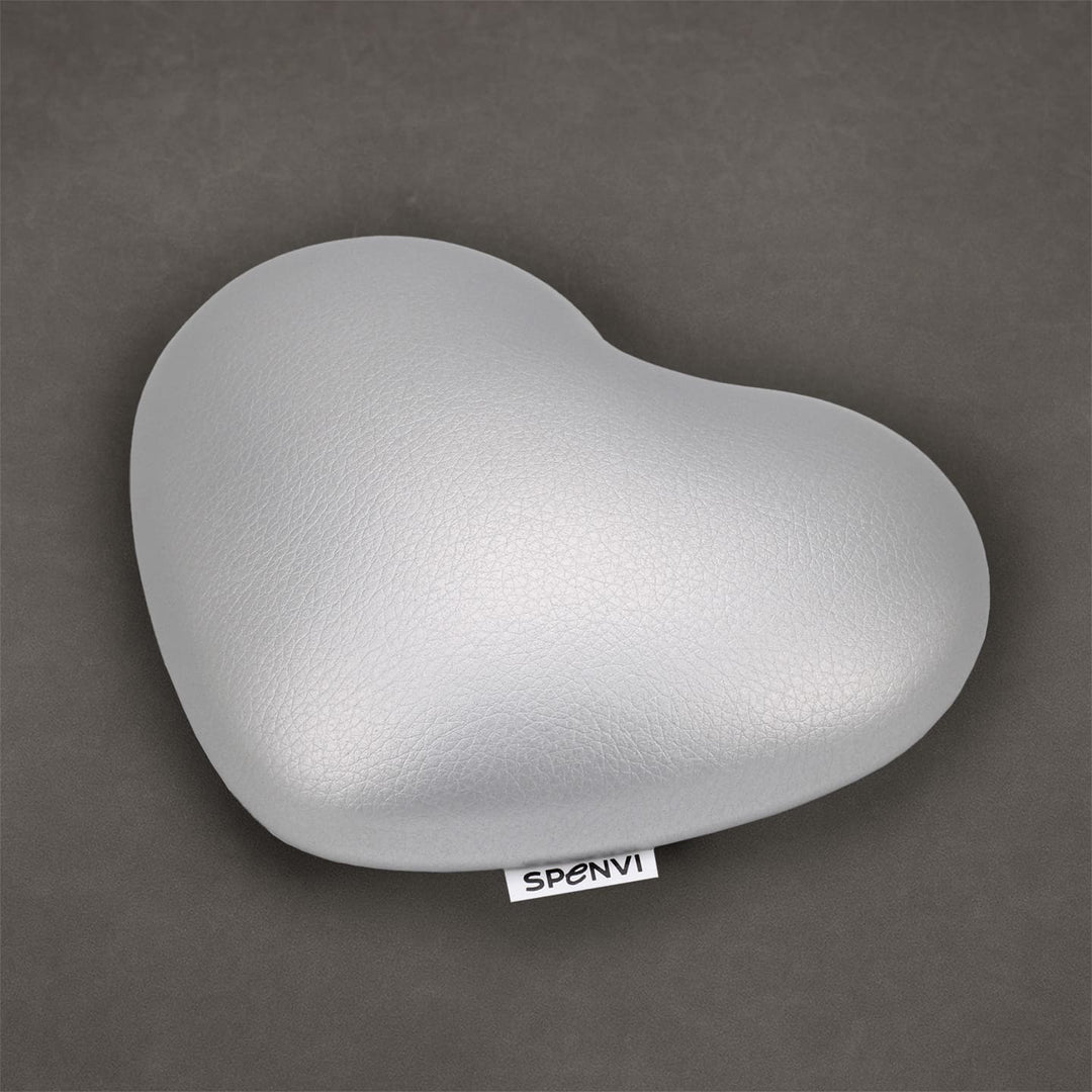 Silver heart-shaped SPENVI nail tech elbow cushion made of soft leather on a textured grey background. #color_silver