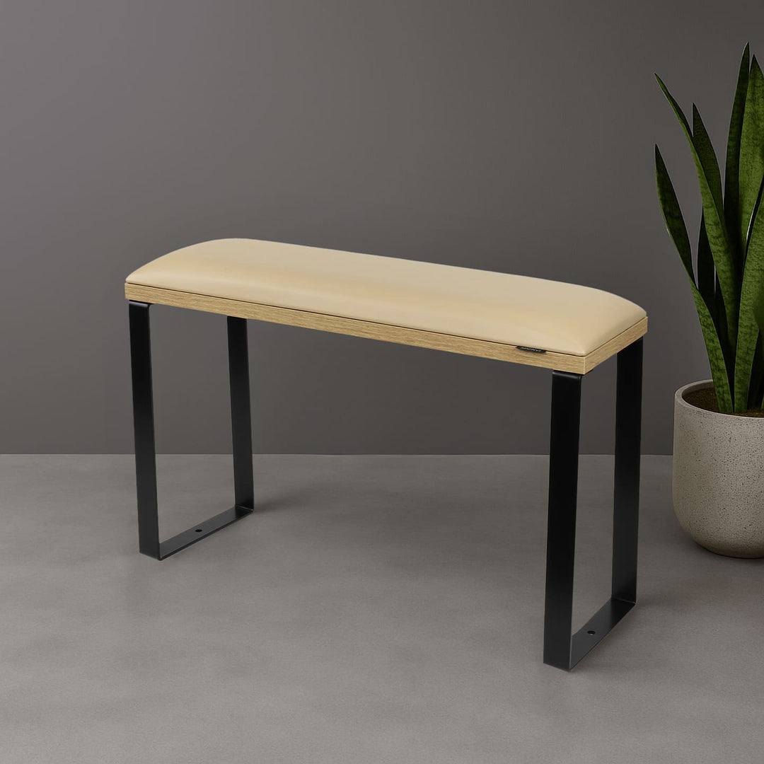 SPENVI Loft pedicure footrest with beige leather cushion, oak-finish base, and black metal legs styled in modern salon interior with plant. #color_coffee-milk