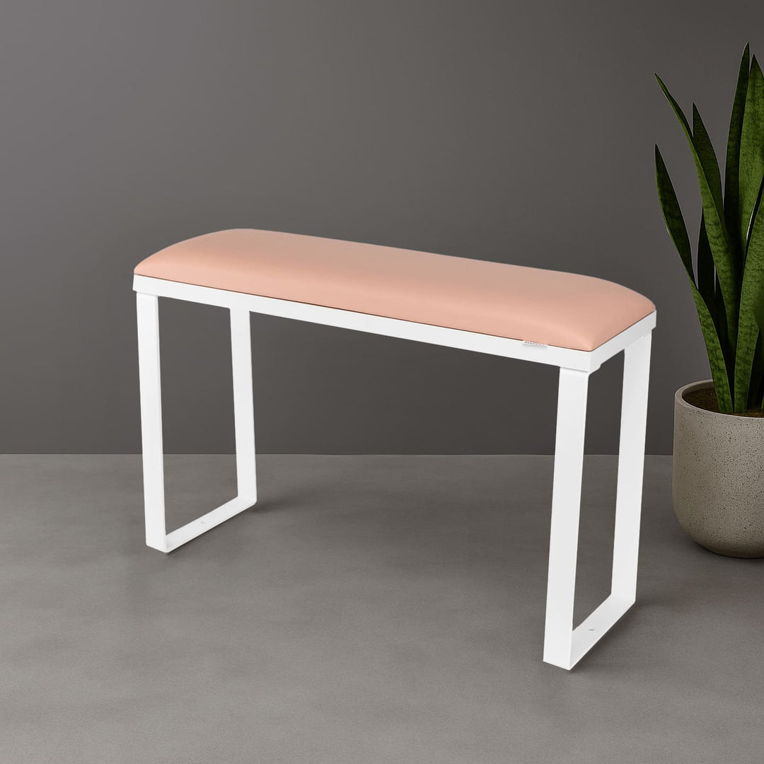 SPENVI Loft pedicure footrest with light pink leather cushion, white base, and white metal legs styled in modern salon interior with plant. #color_light-pink